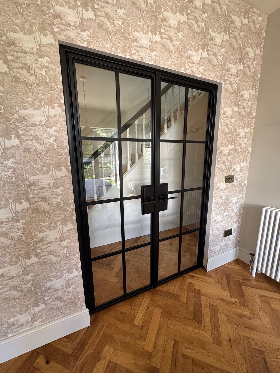 FD30 fire-rated steel double doors onto a staircase, set into a papered wall