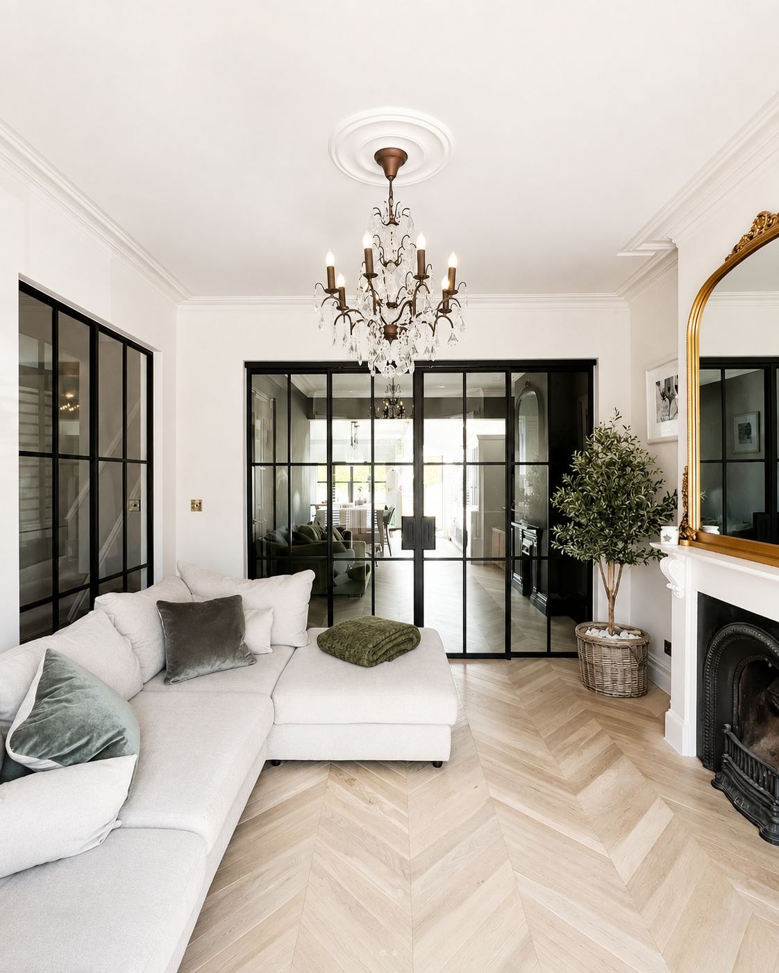 Internal steel doors and screens between a lounge and dining room over chevron oak